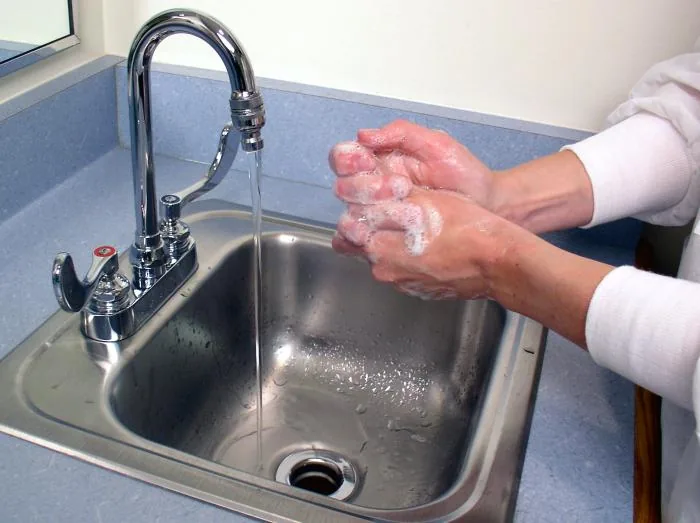 Friction des mains savonnées à un lavabo, photographie pédagogique, 2004.